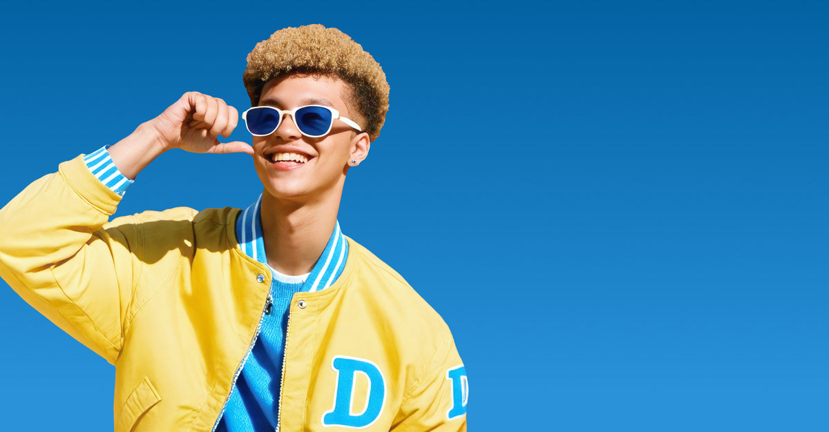 Person wearing a yellow jacket with a blue 'D' logo against a clear blue sky